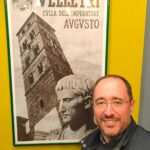Il consigliere Dario Di Luzio posa davanti a un poster che ritrae l'Imperatore e la Torre del Trivio di Velletri
