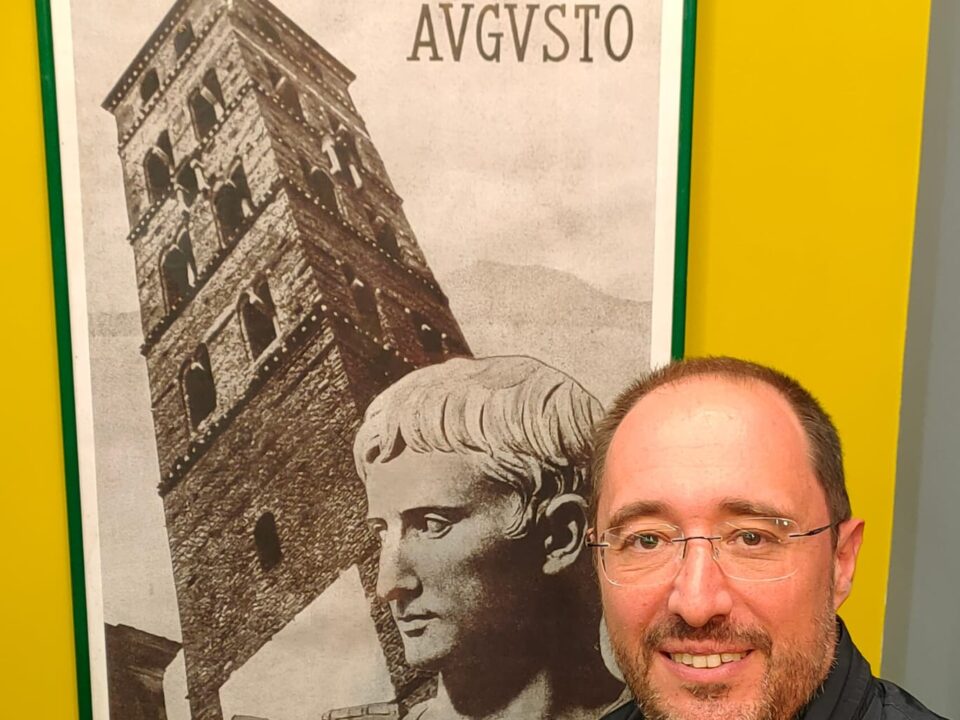 Il consigliere Dario Di Luzio posa davanti a un poster che ritrae l'Imperatore e la Torre del Trivio di Velletri